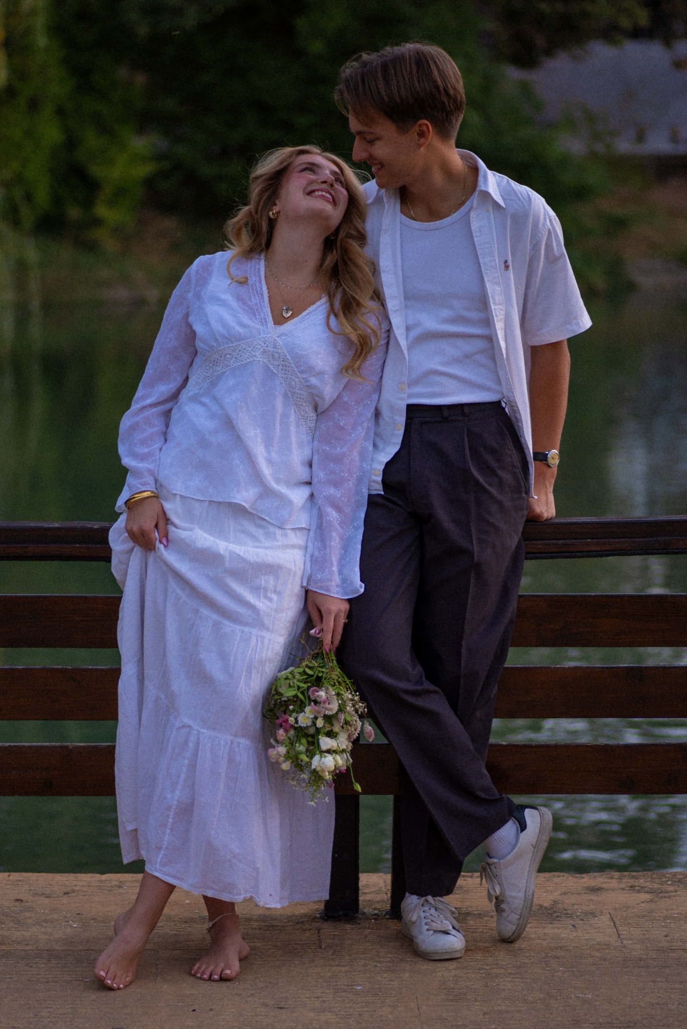 Vikto and Bella smiling at each other beside a lake